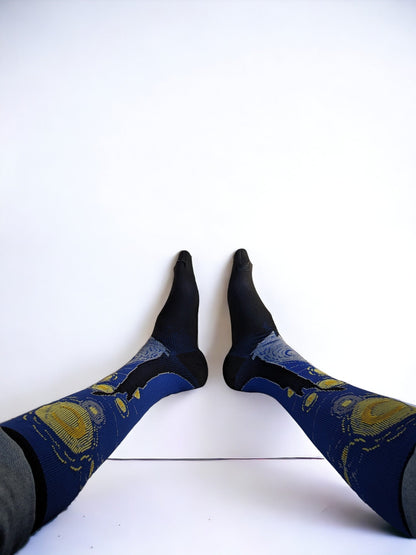 A pair of legs wearing blue compression socks with feet up to the wall