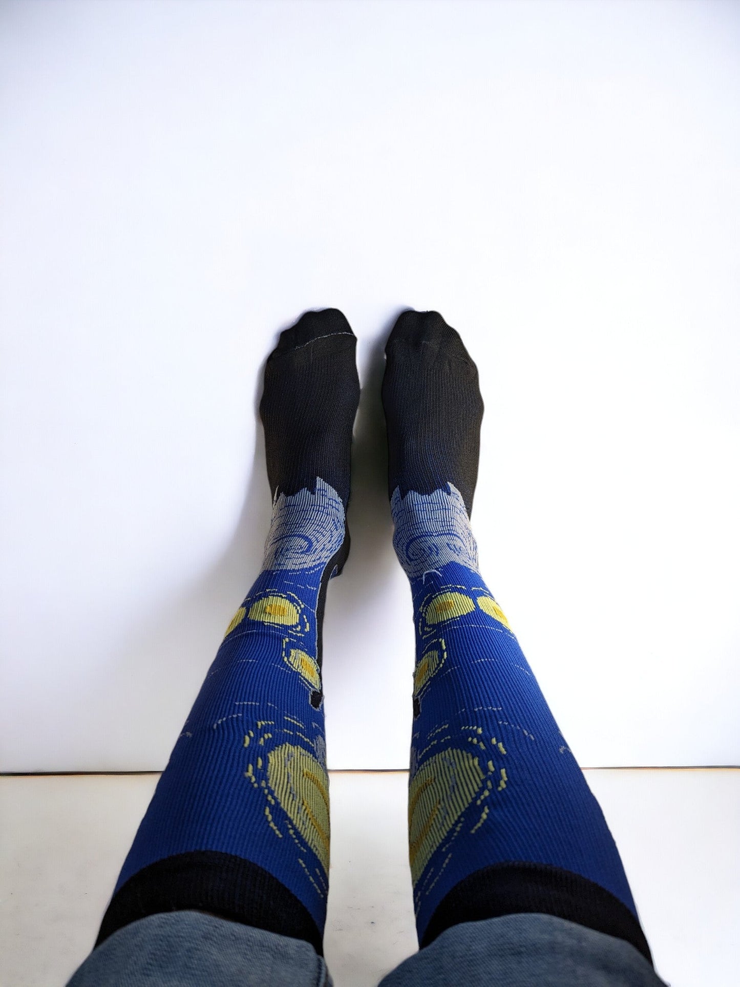 A pair of legs wearing blue compression socks with feet up to the wall