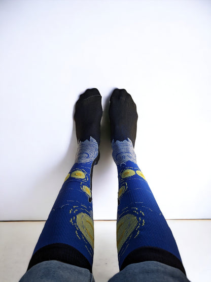 A pair of legs wearing blue compression socks with feet up to the wall