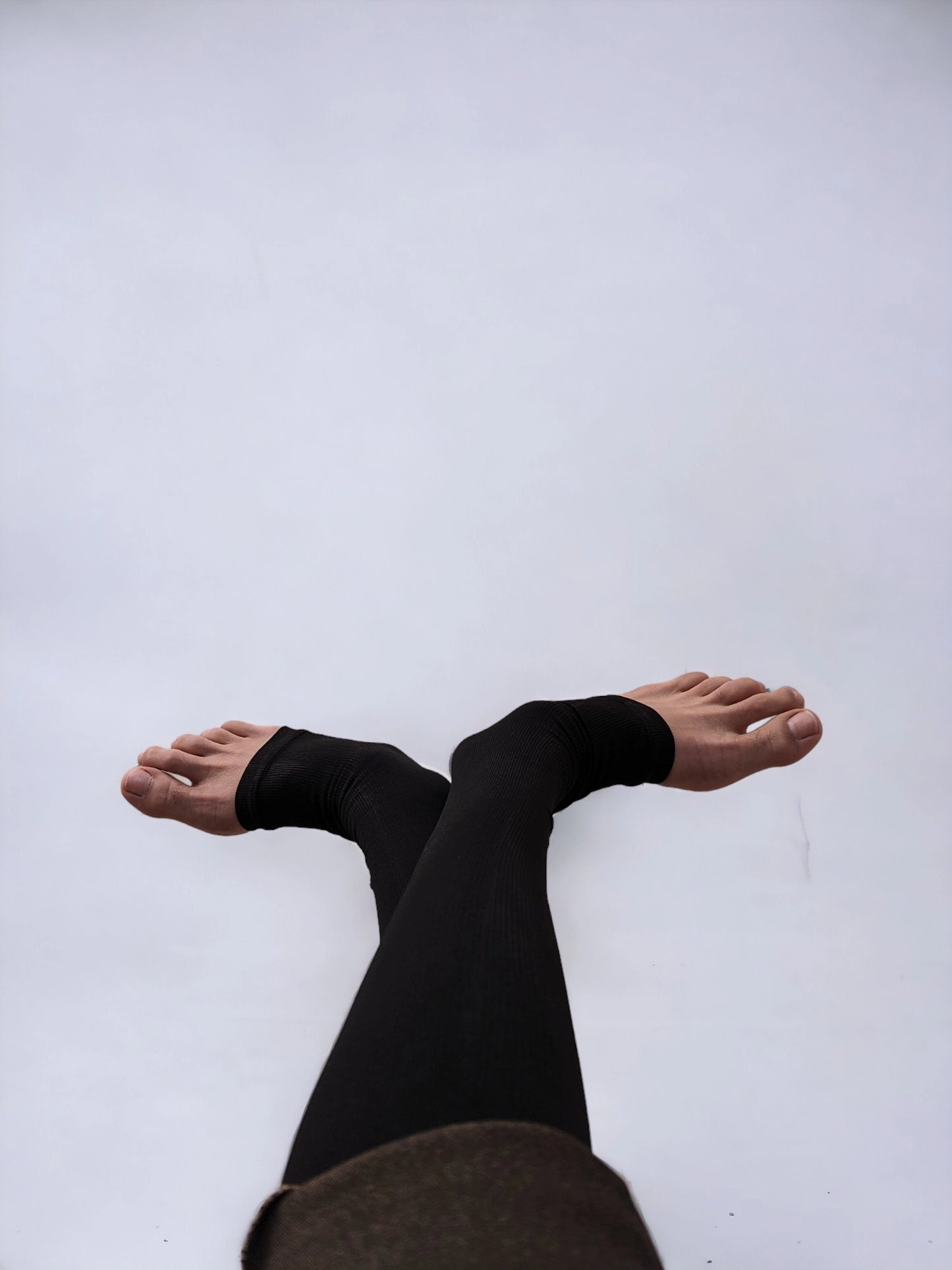 Two legs wearing black colored knee-high zippered compression socks 