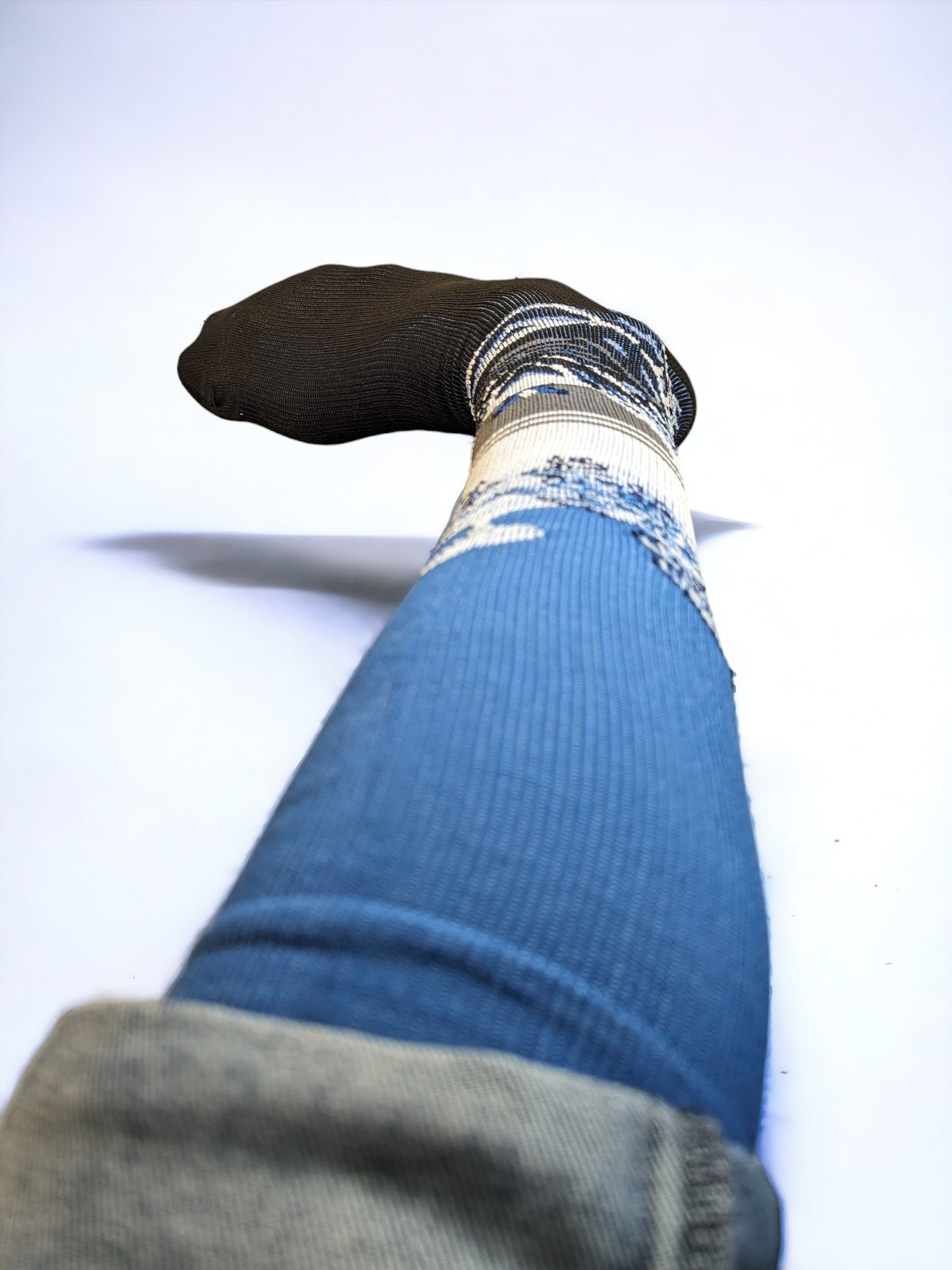 A leg wearing blue compression socks facing towards the front