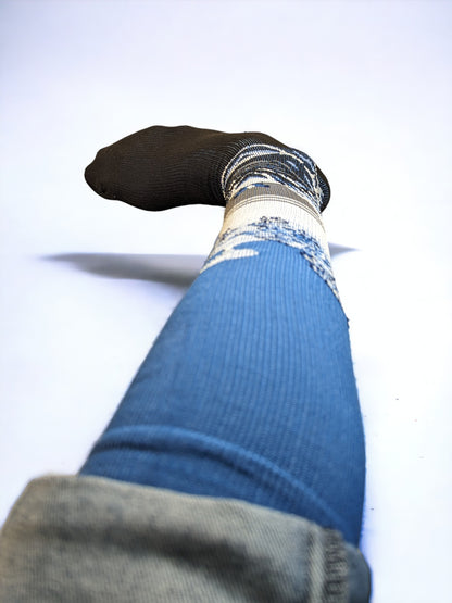 A leg wearing blue compression socks facing towards the front